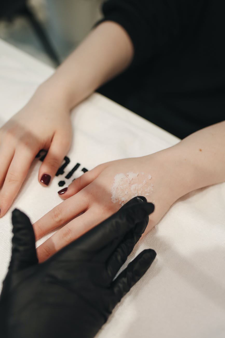 photo of person applying cream to woman s hands