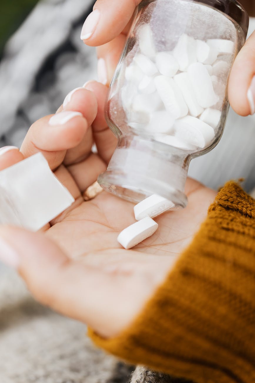 a close up shot of a person taking medicine from a bottle 
Assortment of over-the-counter scar creams